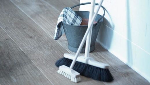 a broom, scrubber brush and metal bucket are ready for use