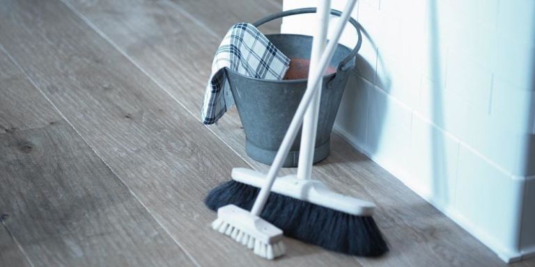 a broom, scrubber brush and metal bucket are ready for use